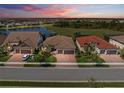 Sunset aerial view of neighborhood homes with tile roofs and manicured lawns at 13230 Rinella St, Venice, FL 34293