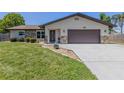 Beautiful home featuring stone accents, a two-car garage, and a well-maintained lawn at 1340 Olympia Rd, Venice, FL 34293