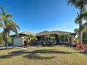 A single-Gathering home with lush landscaping, a covered entry, and an attached garage at 14352 Pocono Ave, Port Charlotte, FL 33981