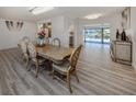 Elegant dining room featuring wood-like flooring and a view of the pool area at 1503 Marlin St, Nokomis, FL 34275
