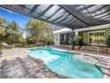 Relaxing pool area features a covered patio, integrated spa, and a beautifully paved deck, perfect for outdoor enjoyment at 1657 Bayshore Dr, Englewood, FL 34223