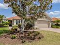 Charming home featuring a well-manicured lawn, mature landscaping, and a two-car garage at 177 Treviso Ct, North Venice, FL 34275