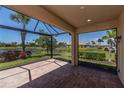 Spacious screened lanai featuring brick flooring and views of the lake and landscaped backyard at 19297 Serafina, Venice, FL 34293