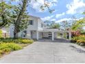 Bright exterior of a two-story home featuring blue shutters and mature landscaping at 200 Sierra S St, Nokomis, FL 34275