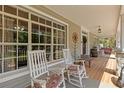 Inviting front porch with rocking chairs, wood flooring, and decorative elements creating a cozy atmosphere at 202 Laurel Oaks Rd, Nokomis, FL 34275