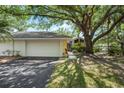 Charming single-story home featuring a lush yard, mature trees, and a two-car garage at 226 Southampton Ln # 257, Venice, FL 34293