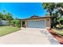 Tan single story house with a two car garage and manicured lawn at 2641 Hyde Park St, Sarasota, FL 34239