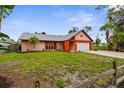 Single-story home featuring a lush green lawn, mature trees, and a convenient two-car garage at 304 Beach Rd, Venice, FL 34285