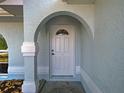 Covered front entryway featuring white pillars, an arched entryway, and light blue exterior paint at 3192 Pinetree St, Port Charlotte, FL 33952