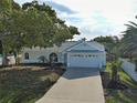 Charming single Gathering home featuring mature trees, light blue exterior, and a spacious two car garage at 3192 Pinetree St, Port Charlotte, FL 33952