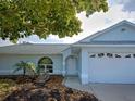 Well maintained single Gathering home with a light blue exterior, inviting entrance, and lush landscaping at 3192 Pinetree St, Port Charlotte, FL 33952