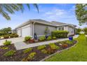 Beautiful single-story home showcasing lush landscaping, bright flower beds, and a well-maintained lawn at 3419 Lakewood Blvd, North Port, FL 34287