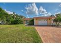 Charming home with attached two-car garage, brick driveway, and a neatly kept lawn at 403 Picasso Dr, Nokomis, FL 34275