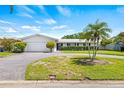 Beautiful single-story home with a circular driveway and lush green lawn at 4255 13Th Ne Ln, St Petersburg, FL 33703