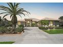 Beautiful home boasting a tile roof, arched windows, and a well-manicured lawn with palm trees at 4321 Via Del Santi Dr, Venice, FL 34293
