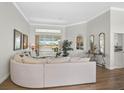 Bright living room featuring wood floors, large windows with a water view, and stylish furnishings at 4321 Via Del Santi Dr, Venice, FL 34293