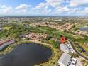 Aerial view of the condominium complex near a peaceful lake and a manicured golf course on a clear day at 442 Sunset Lake Blvd # 104, Venice, FL 34292