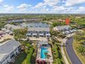A high-angle view showcasing the condo's pool and surrounding greenery in a tranquil lakeside setting at 442 Sunset Lake Blvd # 104, Venice, FL 34292