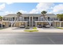 Exterior of condominium featuring covered parking and easy access to units with well-maintained landscaping at 442 Sunset Lake Blvd # 104, Venice, FL 34292