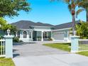 Beautiful blue home featuring an expansive driveway, well manicured lawn, and attached two-car garage at 5035 Collingswood Blvd, Port Charlotte, FL 33948