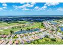Overhead view showcasing a community with lush golf course and water features at 5189 Pine Shadow Ln, North Port, FL 34287