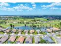 Aerial view of a residential community with lake and golf course in the background at 5189 Pine Shadow Ln, North Port, FL 34287