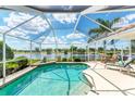 Screened-in pool area featuring serene lake views and comfortable outdoor seating at 5189 Pine Shadow Ln, North Port, FL 34287
