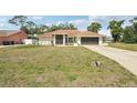 A single-story home with a well-manicured lawn and an extra long driveway at 5417 Maccaughey Dr, North Port, FL 34287