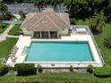 Aerial view of a community pool surrounded by lounge chairs and palm trees at 615 May Apple Way, Venice, FL 34293