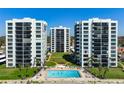 Beautiful exterior view of condo buildings with a pool and well-manicured lawn at 627 Alhambra Rd # 1103, Venice, FL 34285