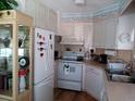 Cozy kitchen featuring white appliances, ample countertop space, and coastal-themed decor at 638 Leisure, Venice, FL 34285