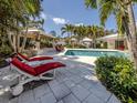 Luxurious backyard oasis features sparkling pool, sun loungers, and covered lounge areas at 701 Laguna Dr, Venice, FL 34285