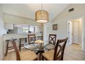 Inviting dining area with a glass-top table, seating for four, and stylish pendant lighting at 758 Bird Bay W Dr # 169, Venice, FL 34285