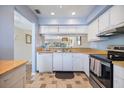 Well-lit kitchen with white cabinets, stainless steel oven, and a view into the dining area at 758 Bird Bay W Dr # 169, Venice, FL 34285