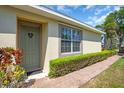 Inviting front entrance with a decorative wreath, lush greenery, and a brick walkway enhancing the home's charm at 9413 Carnaby Dr, Venice, FL 34293