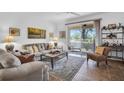 Bright living room with comfortable seating, stylish decor, and sliding glass doors leading to an outdoor space at 9413 Carnaby Dr, Venice, FL 34293