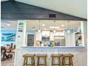 Stylish kitchen pass-through with counter stools, pendant lights, and modern appliances at 1008 Euclid Rd, Venice, FL 34293