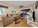 Bright living room with neutral furniture, wood flooring, and sliding glass doors at 11924 Tempest Harbor Loop, Venice, FL 34292