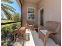 Screened porch featuring neutral chairs and a small side table at 11924 Tempest Harbor Loop, Venice, FL 34292