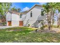 Charming home with a three-car garage, well-maintained lawn, and tropical landscaping at 1500 Lemon Bay Dr, Venice, FL 34293