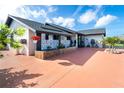 Stylish home showcasing a patterned privacy wall, mature landscaping, and a bright red driveway at 23 Tiffany St, Englewood, FL 34223