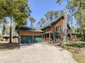 Attractive log home featuring a stone chimney and a convenient two-car garage at 2450 Flagami Ln, North Port, FL 34286