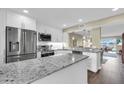 Modern kitchen with granite countertops, stainless steel appliances, and breakfast bar overlooking the dining area at 250 Santa Maria St # 216, Venice, FL 34285