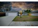 Inviting home with a well-lit exterior and landscaped yard at twilight at 4068 Palau Dr, Sarasota, FL 34241