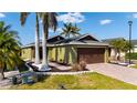 Beautiful home featuring a brick paved driveway, tropical landscaping, and a brown two-car garage door at 4835 San Ortebello Dr, Bradenton, FL 34208