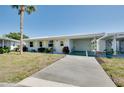Bright single-story home with a carport, fresh white paint, yellow shutters, and a neatly kept lawn at 595 Circlewood Dr # Y4, Venice, FL 34293