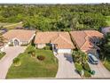 A sunny aerial view shows a terracotta-roofed home with lush landscaping in a well-maintained neighborhood at 8300 Parkside Dr, Englewood, FL 34224