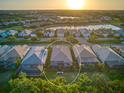Aerial perspective displaying backyard, with lush lawn, in a neighborhood setting, and a scenic lake at 27336 Driver Ln, Englewood, FL 34223