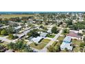 Aerial view of a residential neighborhood featuring lush greenery and the charming light blue home at 100 Aurora W St, Venice, FL 34285
