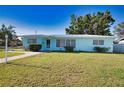 Lovely light blue single-story home with a well-manicured lawn and neat landscaping at 100 Aurora W St, Venice, FL 34285